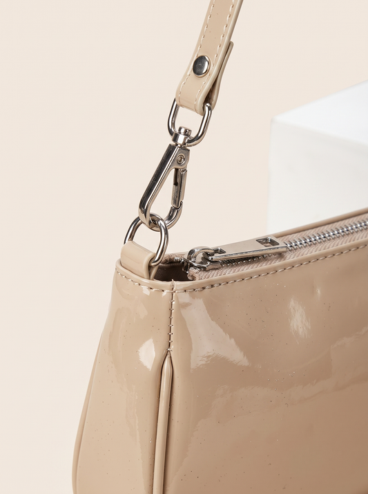 Bolso mini nude brillante, detalle de cremallera y textura efecto charol