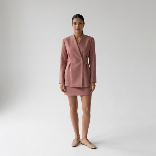 Modelo con conjunto de blazer cruzado sin solapas y minifalda de tweed rosa viejo de NEVAIA, vista frontal