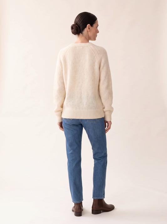 Modelo de espaldas con el jersey oversize efecto mohair crudo de NEVAIA: mangas raglán y canalé ancho