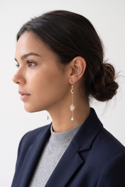 Modelo con pendientes colgantes de perla y dorado de NEVAIA, vista de perfil